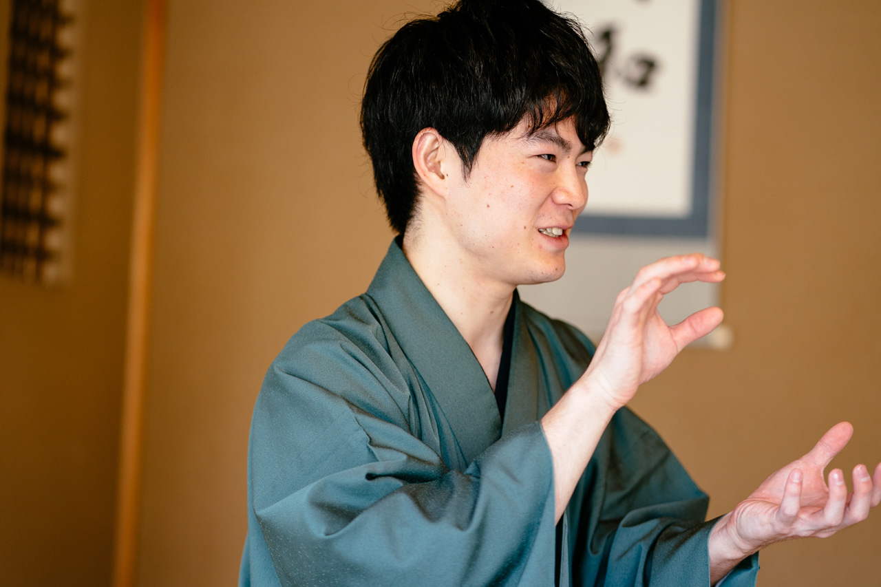 Ryo Iwamoto, smiling while explaining his point and gesturing with both hands