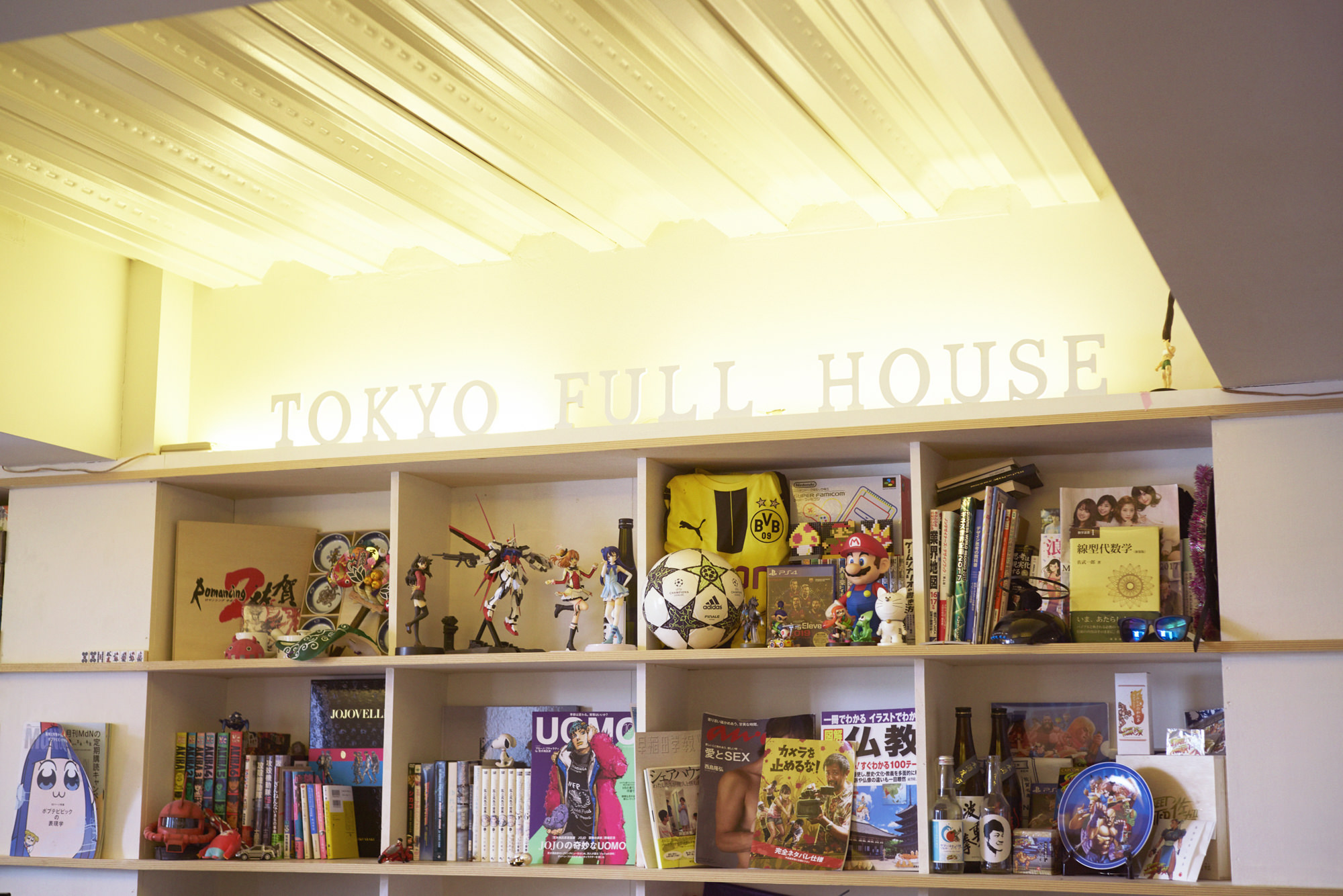 東京フルハウスの屋内の写真。棚にフィギュアや雑誌などが並んでいる