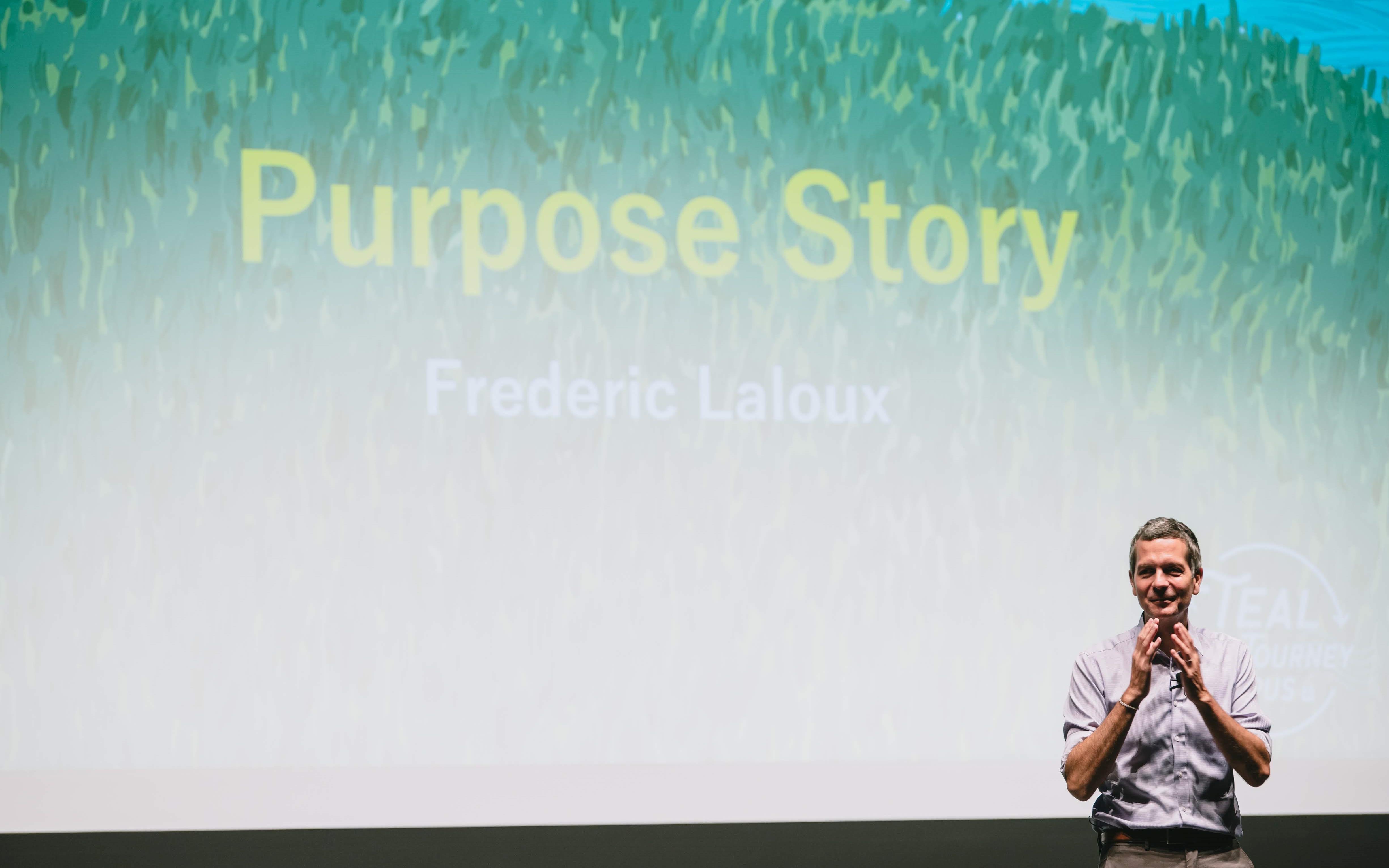 講演のテーマ「Purpose Story」が書かれたスクリーンを背に話すラルーさん
