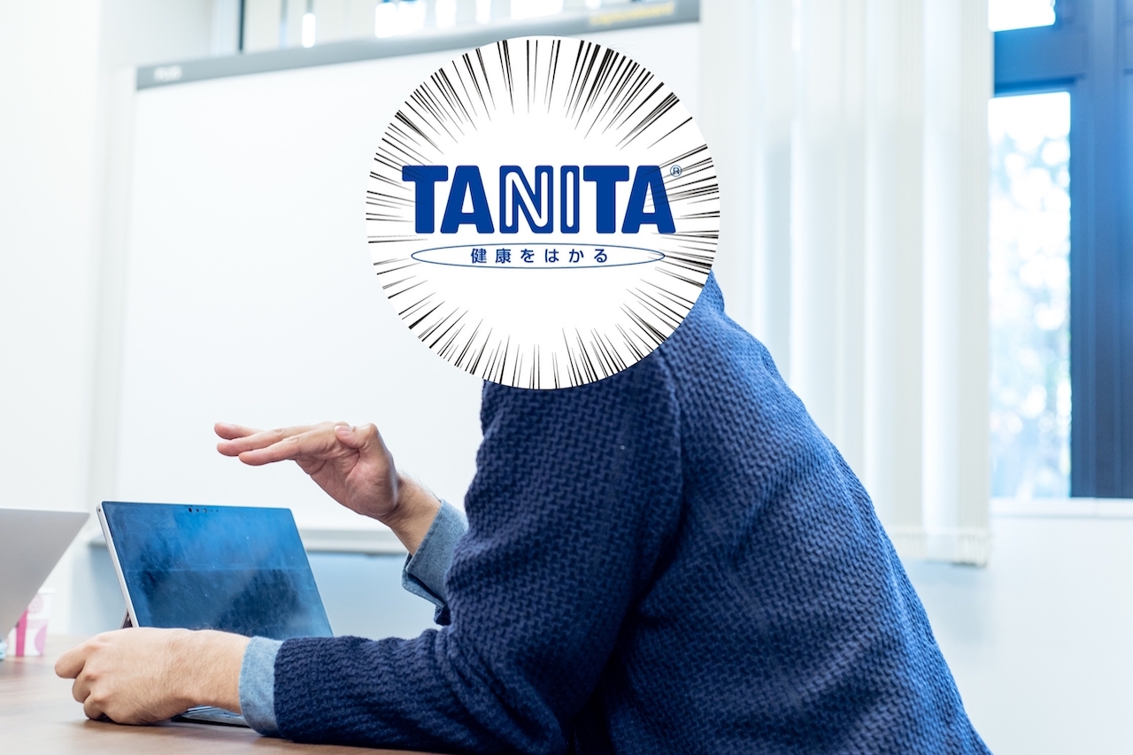 話す中の人。顔はタニタの企業ロゴで隠されている